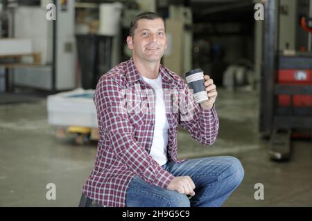 Gutaussehende Fracht worke trinken Kaffee auf einer Einweg-Tasse Stockfoto