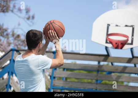 Junger Mann, der Freiwürfe aus der Foul-Linie schießt Stockfoto