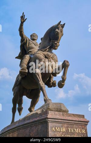 Die große Bronzestatue, Skulptur von Amir Timur auf einem Pferd. Komisch, ein Vogel am Finger. In der Innenstadt von Taschkent, Usbekistan. Stockfoto