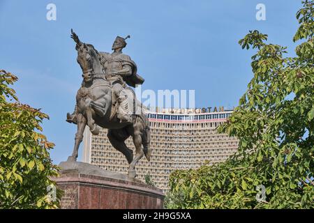 Die große Bronzestatue, Skulptur von Amir Timur auf einem Pferd. Komisch, ein Vogel am Finger. Vor dem Hotel Uzbekistan in der Innenstadt von Taschkent, Usbekistan Stockfoto