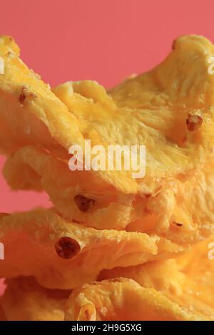 Getrocknete Ananas auf rosa Hintergrund, Süßes Dessert Hintergrund. Rosa Hintergrund. Vitamin-Dessert. Tropische Früchte. Stockfoto