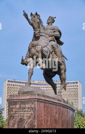 Die große Bronzestatue, Skulptur von Amir Timur auf einem Pferd. Komisch, ein Vogel am Finger. Vor dem Hotel Uzbekistan in der Innenstadt von Taschkent, Usbekistan Stockfoto