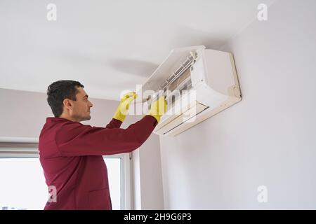 Konzentrierter Reiniger in Gummihandschuhen zur Reinigung der Klimaanlage Stockfoto