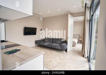 Fragment des Innenraums mit grauem Sofa in der Nähe der Wand Stockfoto