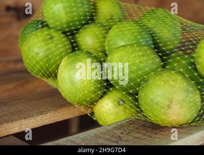 Frische Limetten in einem Netz bereit zu verkaufen Stockfoto