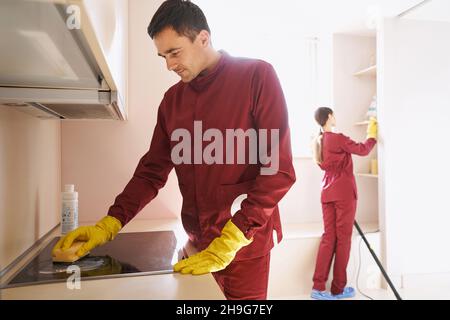 Professionelle Reiniger in Gummihandschuhen Reinigung Küche Stockfoto