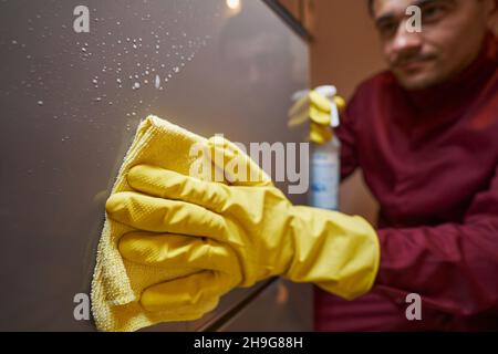 Hausmeister in Gummihandschuhen wischen Schuhschrank Stockfoto