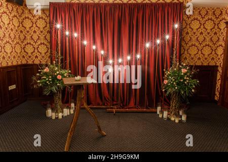 Saal für die Feier der Hochzeit. Schöne rote Innenausstattung mit festlichen Lichtern. Stockfoto