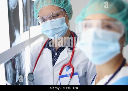 Professionelle Ärztinnen schauen sich Röntgenaufnahmen im Krankenhaus an Stockfoto