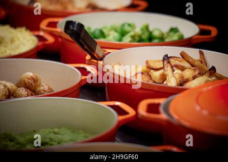 Pub Carvery Selbstbedienungskochtöpfe, Bratkartoffeln, Pastinaken, Brussel-Ausgießen, Stockfoto