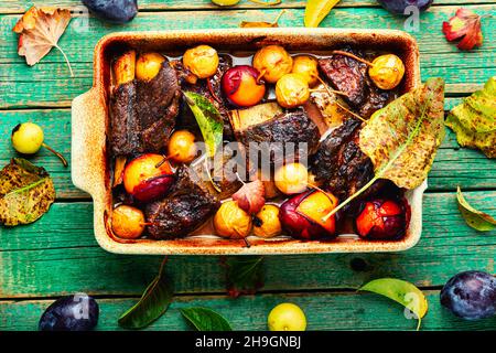 Rinderrippen, gegrillt mit Pflaumen und Birnen in Backform.Fleischrippen in Obstsoße gebraten.Draufsicht Stockfoto