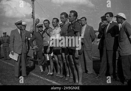 Kraków, 1948-06-30. OD 22 czerwca do 4 lipca odbywa³ siê VII Kolarski Wyœcig Dooko³a Polski (Tour de Pologne). VIII etap z Bytomia do Krakowa (140 km) koñczy³ siê na stadionie klubu sportowego Cracovia. NZ. Kolarze, m.in. Zdobywca III miejsca Wac³aw Wójcik (1L w pierwszym rzêdzie), Lubos Puklicky (Czechos³owacja, 2P w pierwszym rzêdzie) oraz wêgierski kolarz Bela Maedi (Madi) - 1P w pierwszym rzêdzie, w otoczeniu sêdziów i dzia³aczy sportowych. Z lewej sêdzia Feliks St. Go³êbiowski. pw PAP Krakau, 30. Juni 1948. Das Radrennen der Tour de Pologne 7th fand vom 22. Juni bis 4. Juli statt. Der Stockfoto