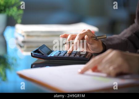 Executive hands Berechnung mit Rechner in der Nacht im Büro Stockfoto