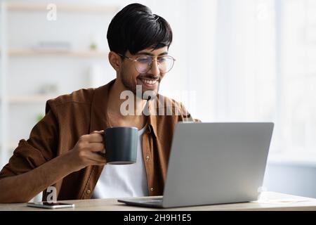 Glücklicher hindu-Typ Freiberufler, der von zu Hause aus arbeitet Stockfoto