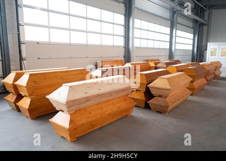 Dresden, Deutschland. 07th Dez 2021. Zahlreiche Särge liegen in einer Lagerhalle auf dem Gelände des Büros für Straßen- und Bauingenieurwesen Dresden. In der Halle, die normalerweise für Hochwasserschutzanlagen genutzt wird, können bis zu 400 Särge gelagert werden. Es soll die Logistik des Bestattungsdienstes vereinfachen, indem es vor der Verbrennung als Zwischenlager dient. Quelle: Sebastian Kahnert/dpa-Zentralbild/dpa/Alamy Live News Stockfoto