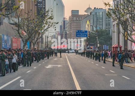 Shanghai, China - 31. Dezember 2016: Menschenmenge und Armee patrouillieren vor Neujahr auf der zentralen Stadtstraße. Stockfoto