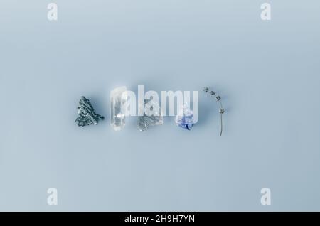 Flache Verlegung von Heilkristallen: Klarem Quarz, rauchigem Quarz, Amethyst, schwarzem Turmalin und getrocknetem Lavendel Stockfoto