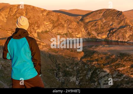 Ein einsamer männlicher Wanderer am Seven Rila Lakes Circus mit Blick auf den Niere Lake bei Sonnenaufgang, Rila Mountain, Bulgarien, Osteuropa, Balkan Stockfoto