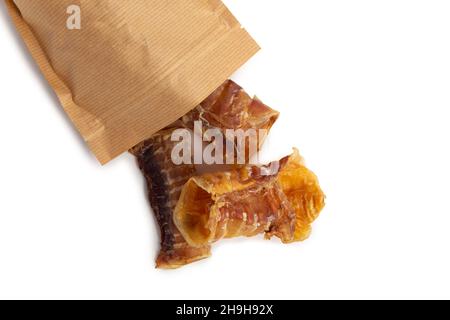 Hundefutter - getrocknete Rinderschlappen, aus der Packung (Luftröhre) auf weißem Hintergrund isoliert gegossen. Natürliche Kauartikel. Stockfoto