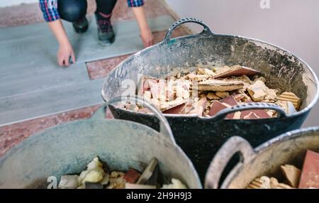 Bauschutt Eimer mit unkenntlichen weiblichen Maurer arbeiten im Hintergrund Stockfoto