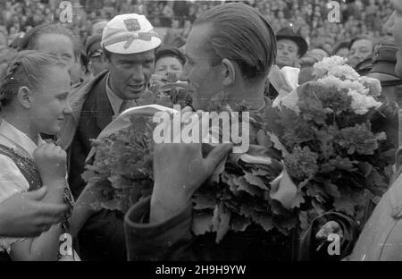 Warszawa, 1948-07-04. OD 22 czerwca do 4 lipca odbywa³ siê VII Kolarski Wyœcig Dooko³a Polski (Tour de Pologne). Ostatni, jedenasty etap z £odzi do Warszawy (134 km) koñczy³ siê na stadionie Wojskowego Klubu Sportowego Legia. NZ. uroczystoœæ wrêczenia wieñca laurowego zwyciêzcy wyœcigu Wac³awowi Wójcikowi (Polska I) (P). Z mikrofonem polski sprawozdawca sportowy Bohdan Tomaszewski. pw PAP/Wojciech Kondracki Warschau, 4. Juli 1948. Das Radrennen der Tour de Pologne 7th fand vom 22. Juni bis 4. Juli statt. Die letzte, elfte Etappe von Lodz nach Warschau (134 km) endete im Stadion des Militärs sp Stockfoto