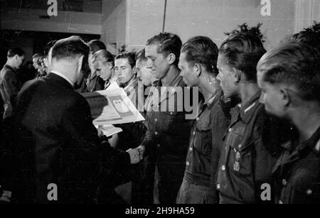 Warszawa, 1948-07-04. W gmachu Roma, przy ul. Nowogrodzkiej, odby³ siê i Krajowy Ogólnopolski Zlot Przodowników pracy Brygad M³odzie¿owych Powszechnej Organizacji S³u¿BA Polsce. Cz³onkom wyró¿nionych brygad wrêczono nagrotty. NZ. minister pracy i opieki spo³ecznej Kazimierz Rusinek (L) wrêcza junakom honorowe dyplomy. pw PAP Warschau, 4. Juli 1948. Die landesweite Kundgebung von 1st junger Arbeiterbanden und des Dienstes an den Arbeitskräften Polens fand im Roma-Theater in der Nowogrodzka-Straße statt. Auszeichnungen und Ehrendiplome wurden an die Mitglieder der besten Banden übergeben. Im Bild: Arbeit und Soziales Welfa Stockfoto