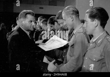 Warszawa, 1948-07-04. W gmachu Roma, przy ul. Nowogrodzkiej, odby³ siê i Krajowy Ogólnopolski Zlot Przodowników pracy Brygad M³odzie¿owych Powszechnej Organizacji S³u¿BA Polsce. Cz³onkom wyró¿nionych brygad wrêczono nagrotty. NZ. minister pracy i opieki spo³ecznej Kazimierz Rusinek (L) wrêcza junakom honorowe dyplomy. pw PAP Warschau, 4. Juli 1948. Die landesweite Kundgebung von 1st junger Arbeiterbanden und des Dienstes an den Arbeitskräften Polens fand im Roma-Theater in der Nowogrodzka-Straße statt. Auszeichnungen und Ehrendiplome wurden an die Mitglieder der besten Banden übergeben. Im Bild: Arbeit und Soziales Welfa Stockfoto