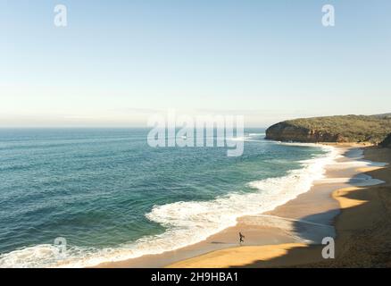 Ein Surfer, der am Bells Beach nahe Torquay am Anfang der Great Ocean Road in Victoria, Australien, ins Meer einsteigt. Stockfoto