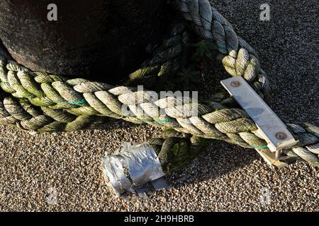 Hochbelastbare Seile sichern ein Fischerboot an einem Poller im Scarborough Harbour. Synthetische Materialien haben Sisal- und Jute-Seile ersetzt, da sie länger halten Stockfoto