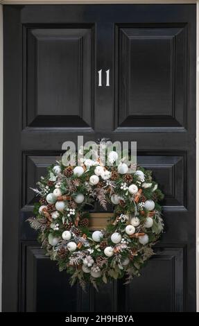 Downing Street, London, Großbritannien. 7. Dezember 2021. Weihnachtskranz an der Eingangstür der Downing Street 11, der Heimat des britischen Schatzkanzlers. Kredit: Malcolm Park/Alamy Stockfoto