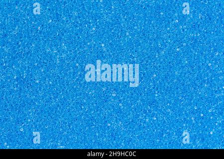 Schaum Schwamm poröse Textur Hintergrund tief himmelblau Farbe. Extreme Nahaufnahme eines einzigartigen abstrakten Kunststoffmaterials. Horizontale Zusammensetzung Stockfoto