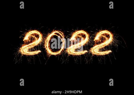 2022 Happy New Year Feuerwerk geschrieben funkelnden Wunderkerzen in der Nacht. Holiday 2022 Wallpaper-Konzept Stockfoto