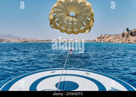 Ältere weiße Frau mit grauen Haaren ist furchtlos und macht Spaß beim Parasailing über dem Roten Meer. Stockfoto