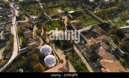 Blick von oben auf den grünen kleinen privaten Park in der Stadt. Aufnahme. Die farbenfrohe Altstadt liegt in einer abgeschiedenen Gegend, umgeben von Bergen. Stockfoto
