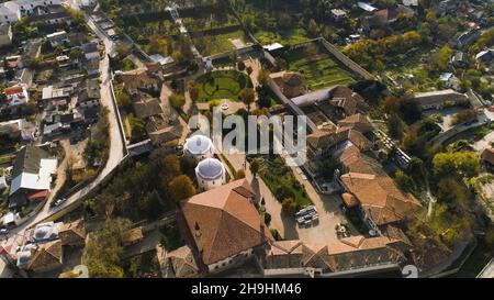 Blick von oben auf den grünen kleinen privaten Park in der Stadt. Aufnahme. Die farbenfrohe Altstadt liegt in einer abgeschiedenen Gegend, umgeben von Bergen. Stockfoto