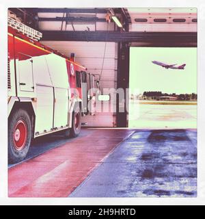 Ein Feuerwehrmotor am Flughafen Gatwick mit einem Virgin Atlantic Flugabflug (Aus einer Reihe von Bildern, die mit dem aufgenommen und verarbeitet wurden IPhone) Stockfoto