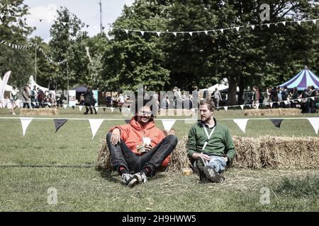 Festivalbesucher entspannen sich beim Field Day Festival im Victoria Park in London in der Sonne Stockfoto