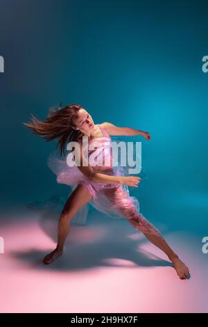 Solo-Performance. Schöne flexible contemp Tänzer tanzen mit Stoff isoliert auf gradient blau weißen Hintergrund in Neonlicht Stockfoto