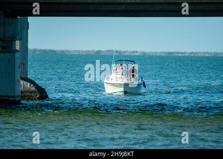 Eine Familie fährt auf einem Boot unter dem Overseas Highway in der Nähe von Big Pine Key, Florida, USA. Stockfoto