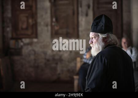 Ein orthodoxer christlicher Priester in der Kirche des Grab des Heiligen in Bethlehem. Allgemeine Ansichten einer von der britischen Wohltätigkeitsorganisation Medical Aid for Palestinans im Jahr 2015 organisierten Benefiz-Radtour durch das Westjordanland von Palästina Stockfoto