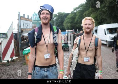 Ein Festivalbesucher, der mit einem Kochtopf auf dem Kopf in Glastonbury ankommt. Aus einer Serie von Fotos, die Menschen zeigen, die am ersten Tag in Glastonbury 2016 auf der Worthy Farm im Regen eintreffen Stockfoto