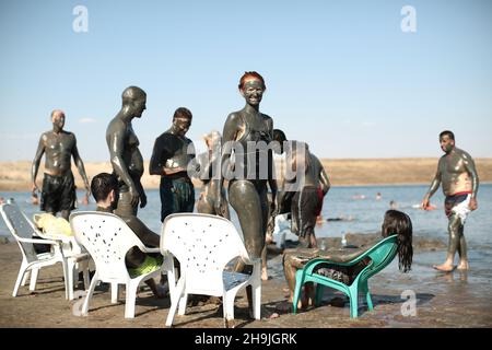 Badegäste im Toten Meer bedecken sich mit Schlamm, der angeblich positive Auswirkungen auf die Haut hat. Aus einer Serie von Fotos, die von der britischen NGO Medical Aid for Palestinans (MAP) in Auftrag gegeben wurden. Der Bildnachweis sollte lauten: Richard Gray/Empics Entertainment Stockfoto