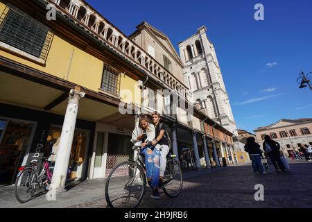 Eine allgemeine Ansicht eines Radfahrers, der eine Frau trägt, die in Ferrara in Italien ihr Telefon überprüft. Aus einer Serie von Reisefotos in Italien. Fototermin: Sonntag, 17. September 2017. Bildnachweis sollte lauten: Richard Gray/EMPICS Entertainment Stockfoto