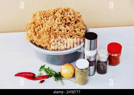 Großer Blumenkohlpilz (Sparassis crispa), Gläser mit Gewürzen, Zwiebel und Pfeffer zur Zubereitung der Suppe auf dem weißen Tisch. Sparassis stimulieren das Immunsystem. Stockfoto