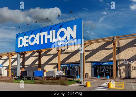 Moncieri, Turin, Italien - 6. Dezember 2021: Decathlon-Logo auf dem Schild am Eingang des Geschäfts am blauen Himmel mit Wolken, Decathlon ist das größte Sportartikelgeschäft Stockfoto