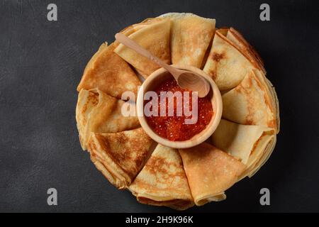 Pfannkuchen mit rotem Kaviar. Fastnacht-Maslenitsa-Woche-Festessen. Stapel russischer Pfannkuchen mit rotem Kaviar. Rustikaler Stil Stockfoto