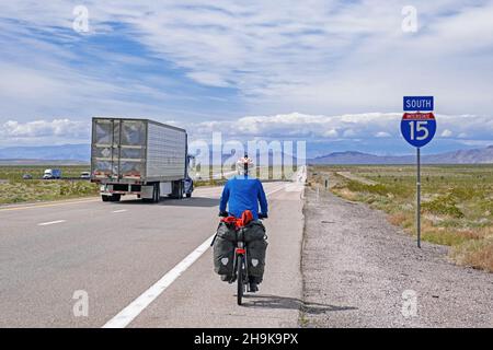 Einsamer Radler, der auf der Interstate 15 / I-15 durch Mohave County in Arizona radelt und nach Las Vegas, USA, fährt. Stockfoto