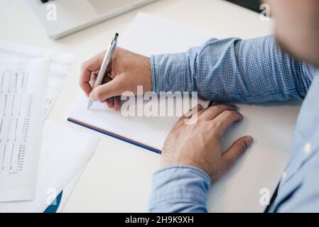 Mann hält Stift Bleistift in der Hand Füllen Schreiben Notizen in Notizen Start neues Kapitel Unternehmer sauber Start neue frische Idee top tun Stockfoto