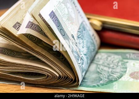 Dickes Paket gefalteter 100 Zloty-Banknoten aus Polen, Tisch, Brieftasche, Nahaufnahme Stockfoto