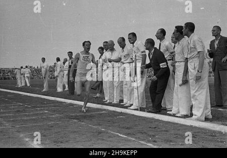 Warszawa, 1948-08-22. Pierwsze ogólnopolskie Igrzyska Sportowe Zwi¹zków Zawodowych (19-22 VIII) na stadionie Wojskowego Klubu Sportowego Legia, w których rywalizowali w 11 dyscyplinach reprezentanci 17 zwi¹zków zawowych. NZ. Finiszuje sztafeta Zwi¹zku Zawodowego Metalowców. ka PAP Warschau, 22. August 1948. Die Olympischen Spiele 1st der Nationalen Gewerkschaften (Aug 19-22) auf Legia, dem Militärsportverein, in dem Vertreter von 17 Gewerkschaften in 11 Disziplinen gegeneinander antraten. Im Bild: Ein Mitglied des Staffelteams der Metallarbeiter-Gewerkschaften überquert die Ziellinie. ka PAP Stockfoto